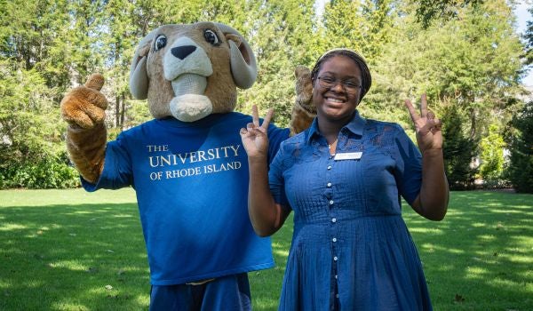 a staff member stands with rhody the ram