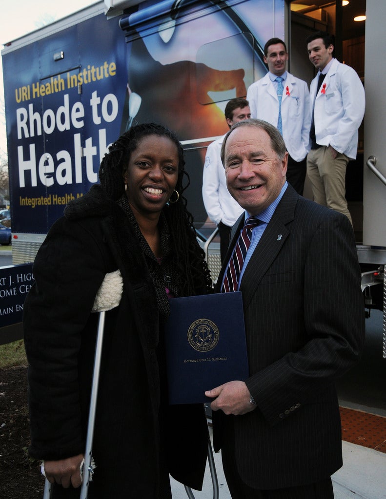 Dr. Nicole Alexander standing with President Dooley in front of the URI Health Institute Rhode to Health bus