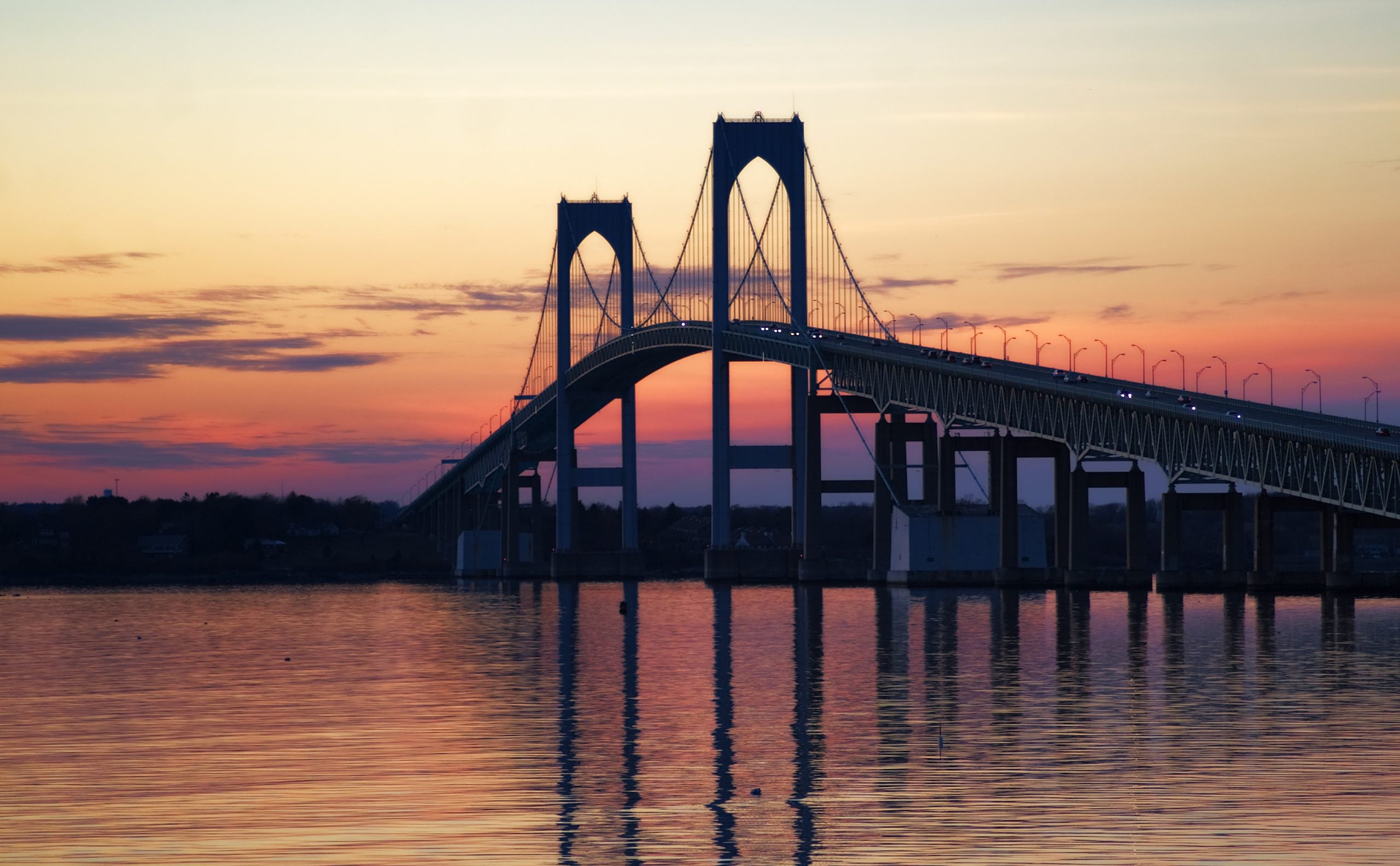 a colorful sunset behind the Newport Bridge