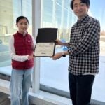 Helen Ly is awarded a certificate of her scholarship from Assistant professor Yeonho Jeong