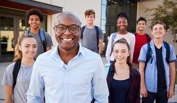 Portrait Of High School Students With Teacher Outside College Buildings