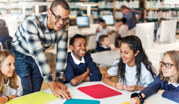 a teacher with a group of students at a table
