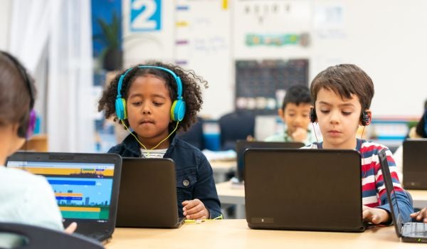 young students using laptops in classroom