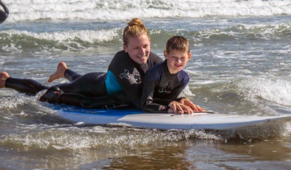 a phys ed teacher and student surf together