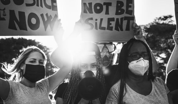 three women protesting with signs