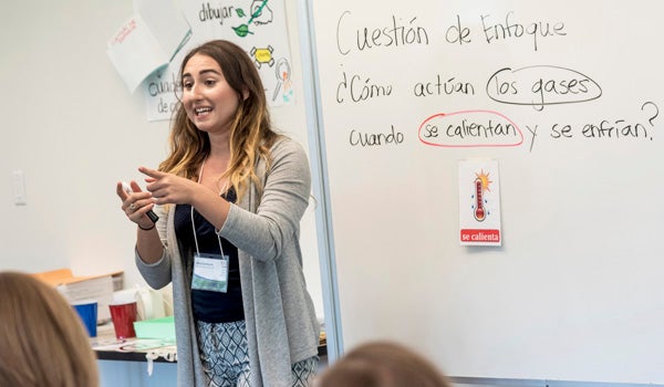 a teacher stands at the front of a classroom