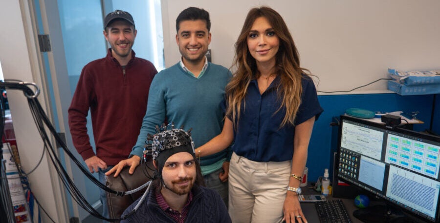 Ph.D. students John McLinden and Behtom Adeli stand with associate professor Yalda Shahriari and master’s degree student Alex Cerullo, seated, in the NeuralPC Lab