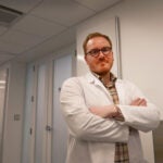 Dr. Poling-Skutvik poses arms crossed in his white lab coat