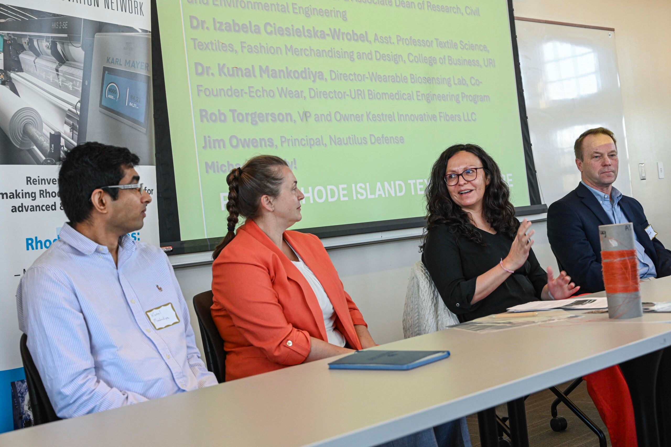 Faculty sit at a table to discuss the new textiles council