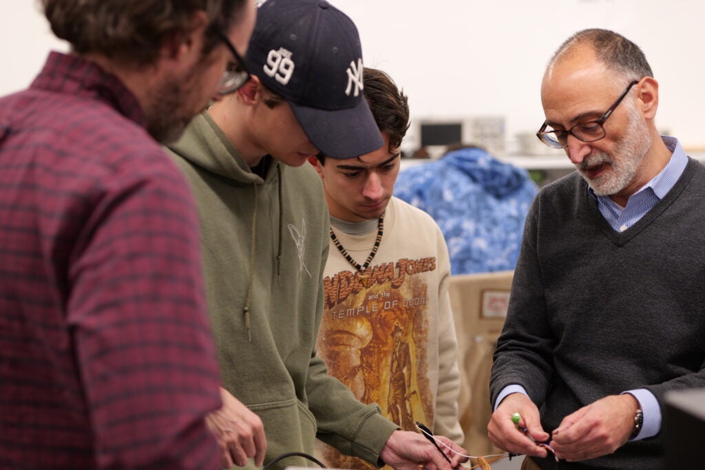 Jouaneh in mechtronics lab demonstrating a device to three students