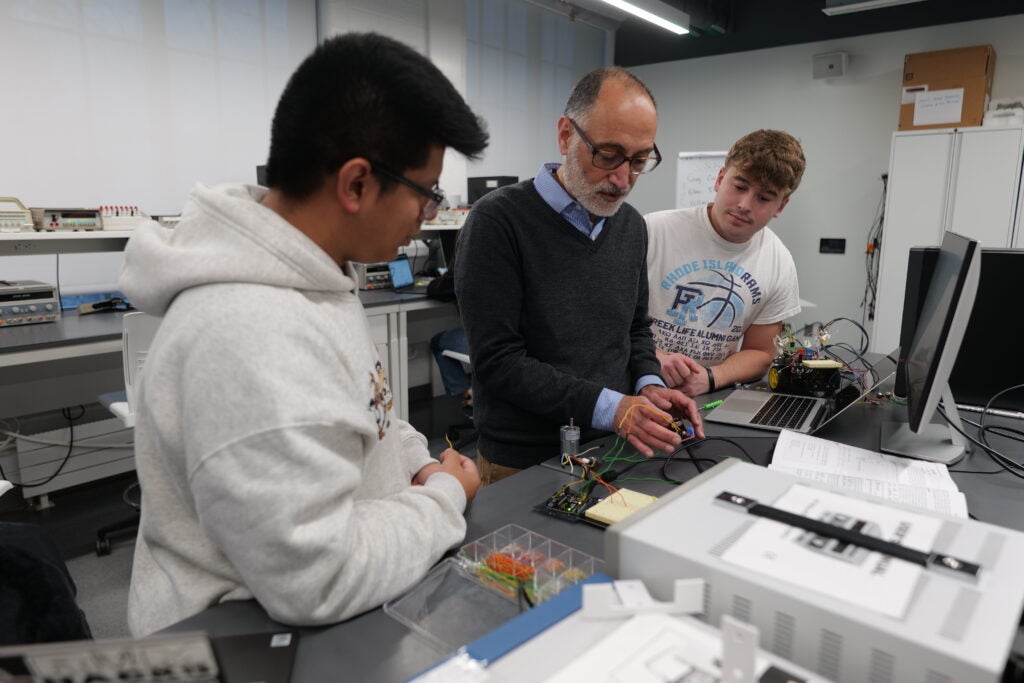 Jouaneh looks over a robotic car project with two students