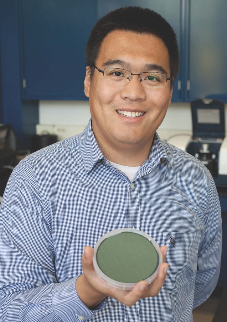 Yi Zheng holding a nano fabricated wavelength selective thermal emitter for solar cells. Photo by Beau Jones