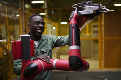 a student works with a robotic arm