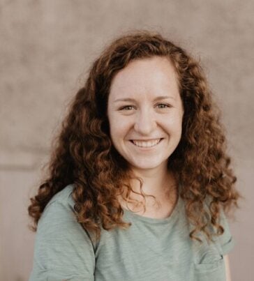 A headshot of Robyn Johnson wearing a light green shirt in front of a neutral background.