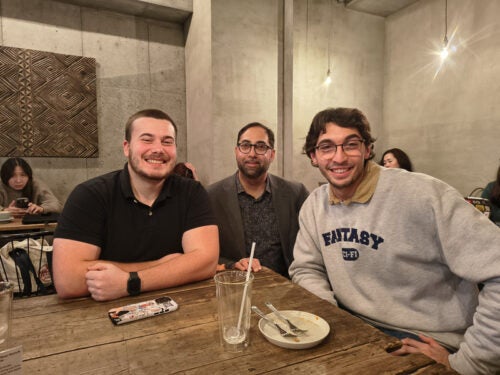 Three members of URI pose at a restaurant in Japan