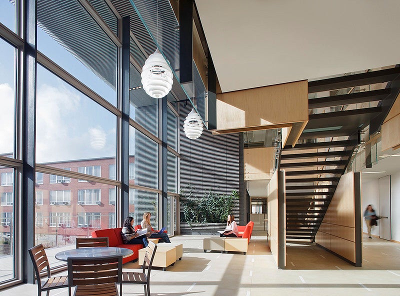Photo of a lobby, showing two individuals studying.