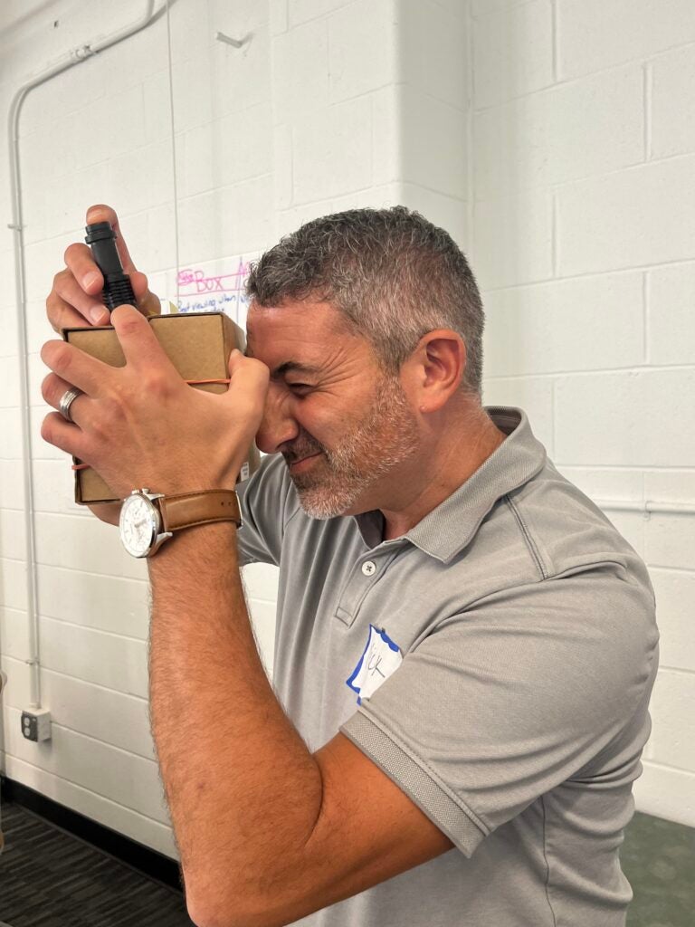 a teacher looks through a device at a professional learning day