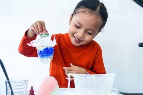 a young child tries a science experiment