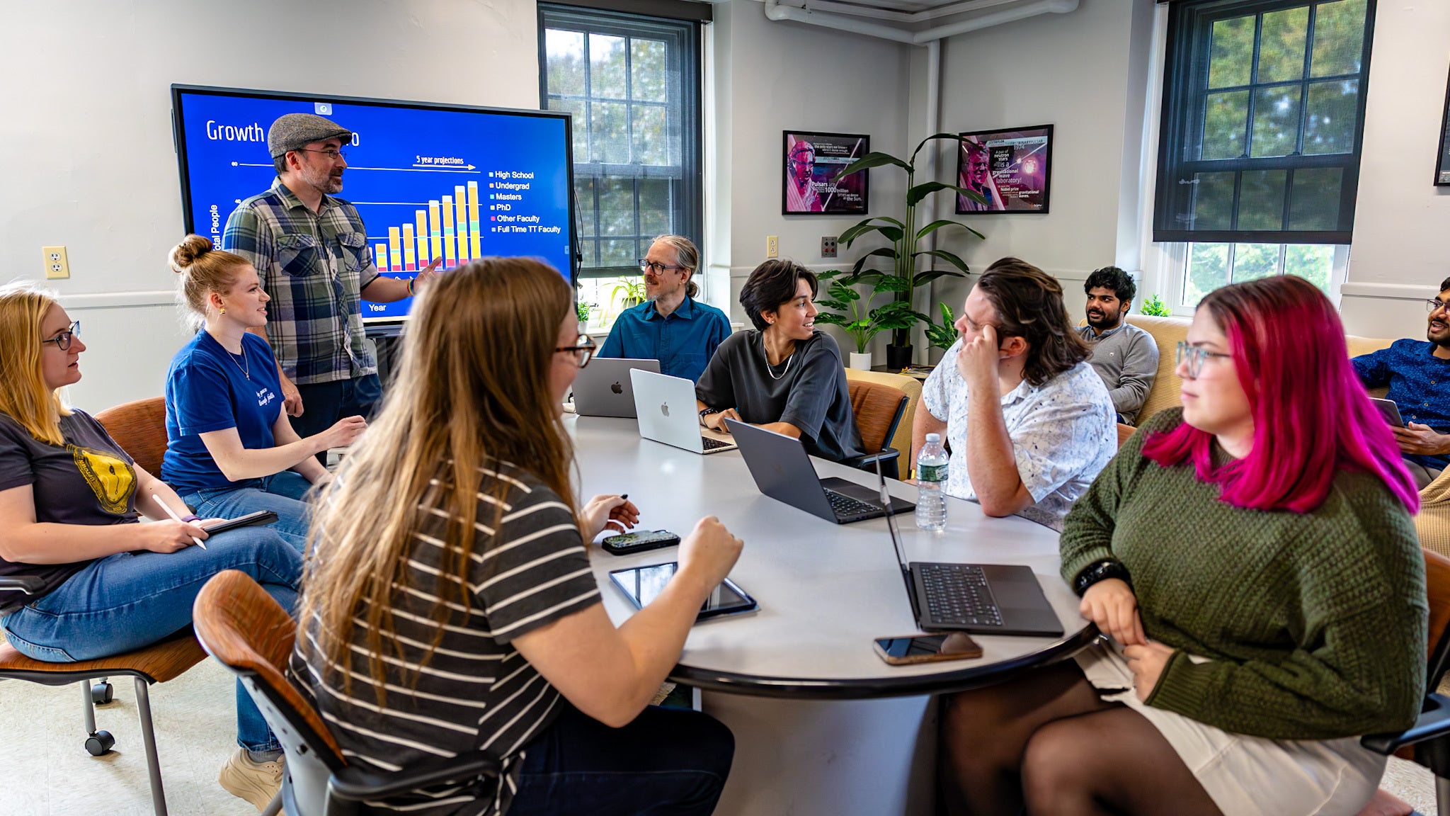 A group of U²GRC students and faculty having an energetic discussion in URI's "AstroSpace" common area.
