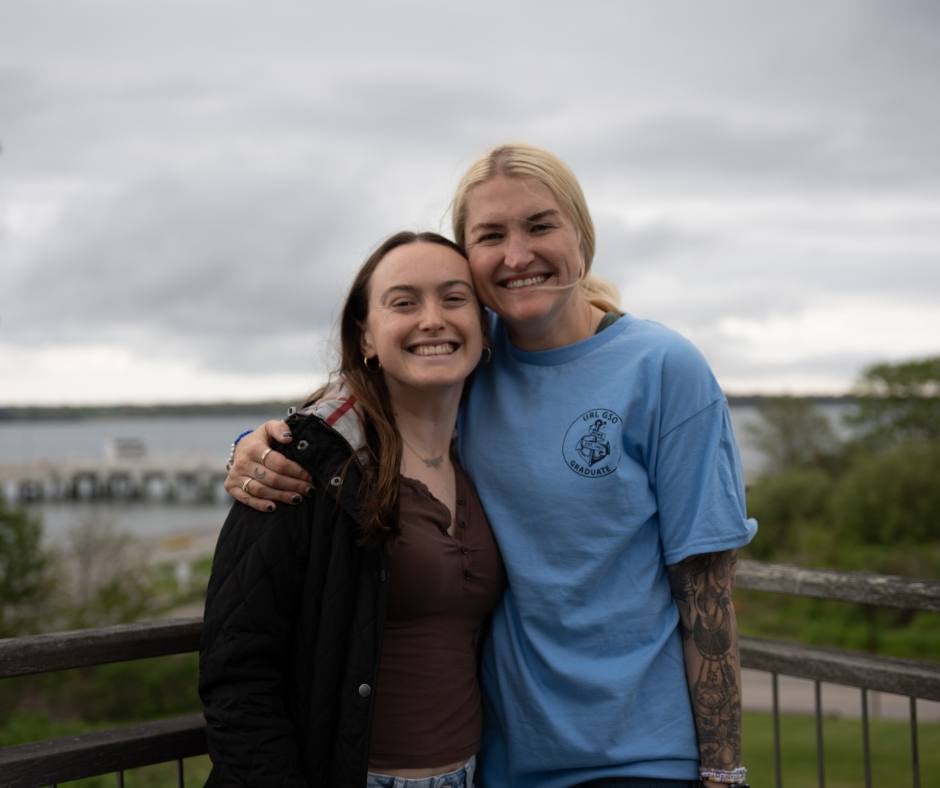 Two students smile on the deck of Mosby.