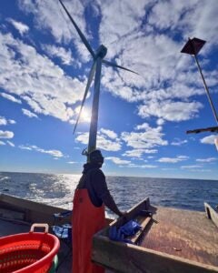 URI Ph.D. student Emmanuel Oyewole conducting field work on the deck of a vessel at the South Fork Wind farm turbines.