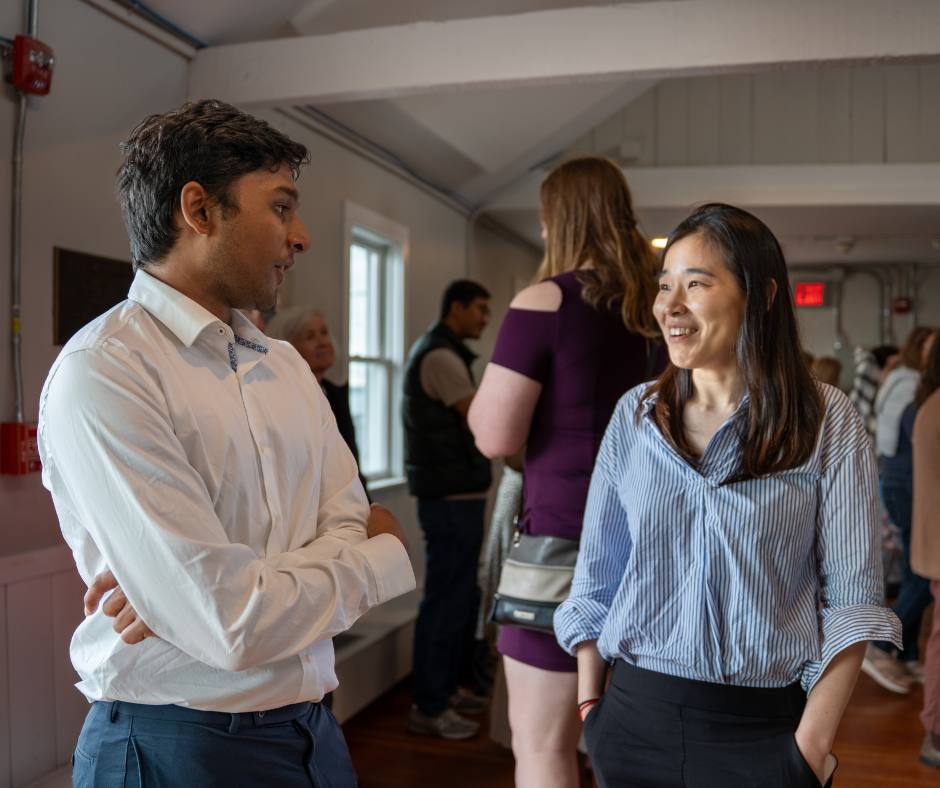 Two new graduates talk in Mosby at the reception.