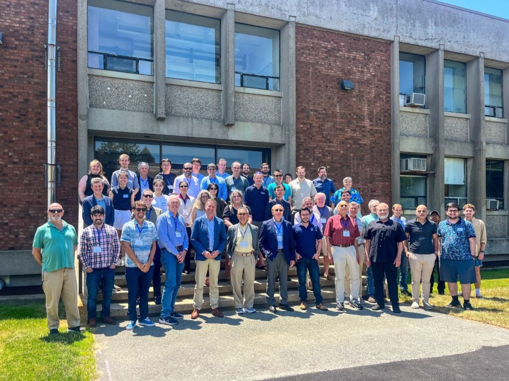 Attendees of the Air-Sea Symposium pose for a group photo in front of the Horn Building at GSO.