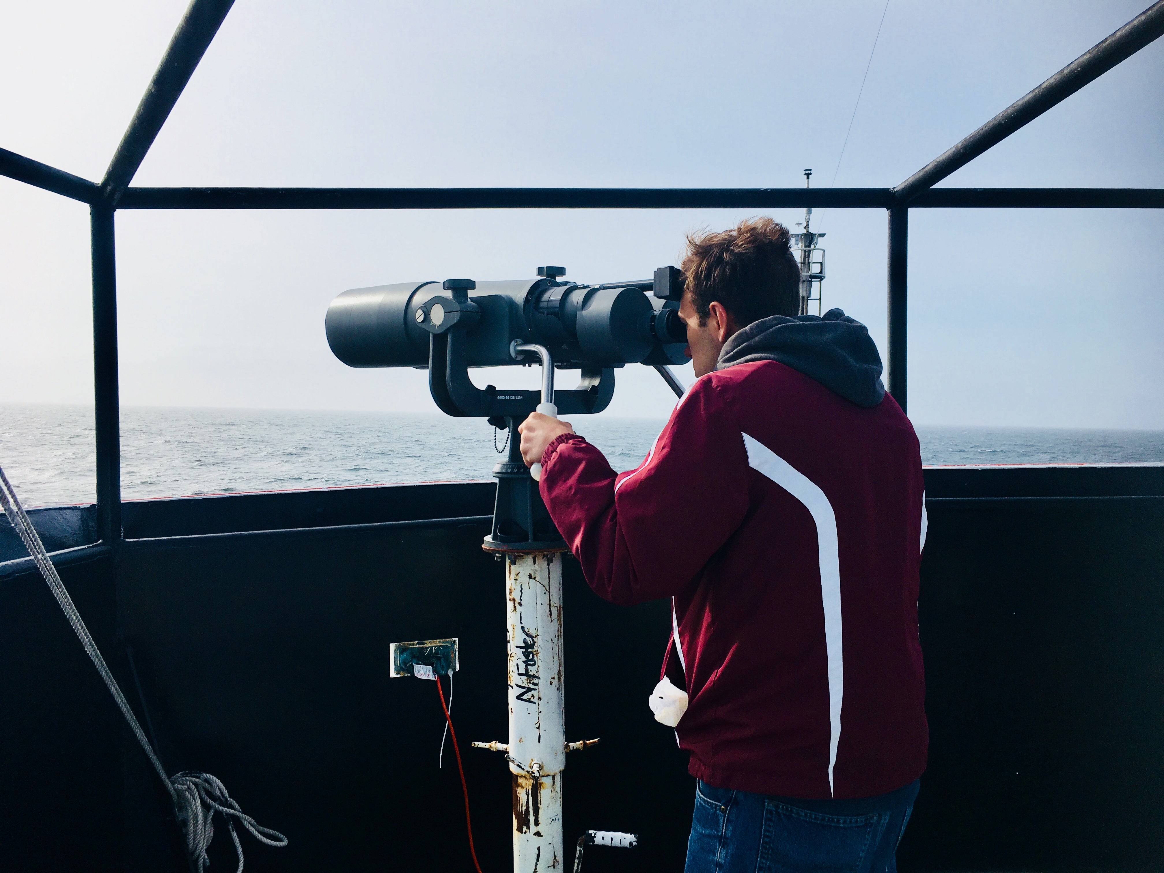 URI student Nick Housman scans for whales with Endeavor’s “big eye” binoculars