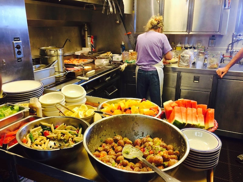 A person cooking food in the galley of a research vessel. 