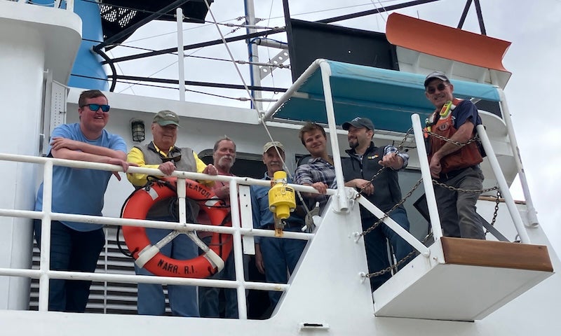 Seven current and former captains and crew of the Endeavor posing for a photograph. 