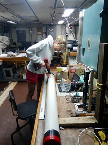 A scientist analyzes a sediment core in a lab.