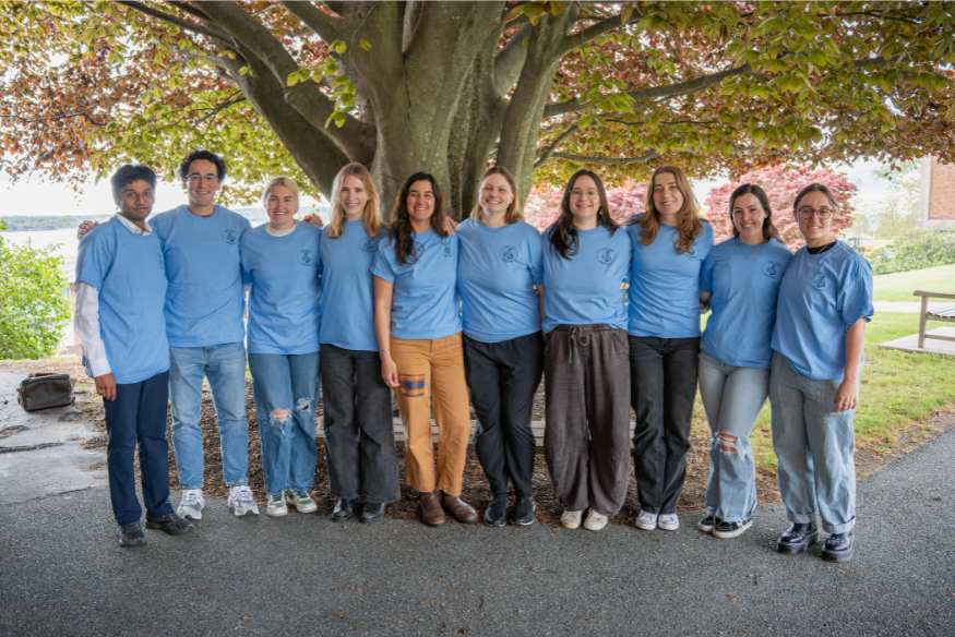 Group of new grads in blue shirts.