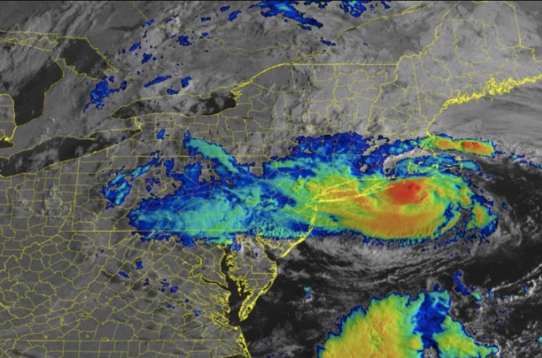 Satellite image of a tropical storm approaching New England. THe storms is depicted in numerous color, ranging from blue at the outskirts to green, yelloe, orange, then red at the center.