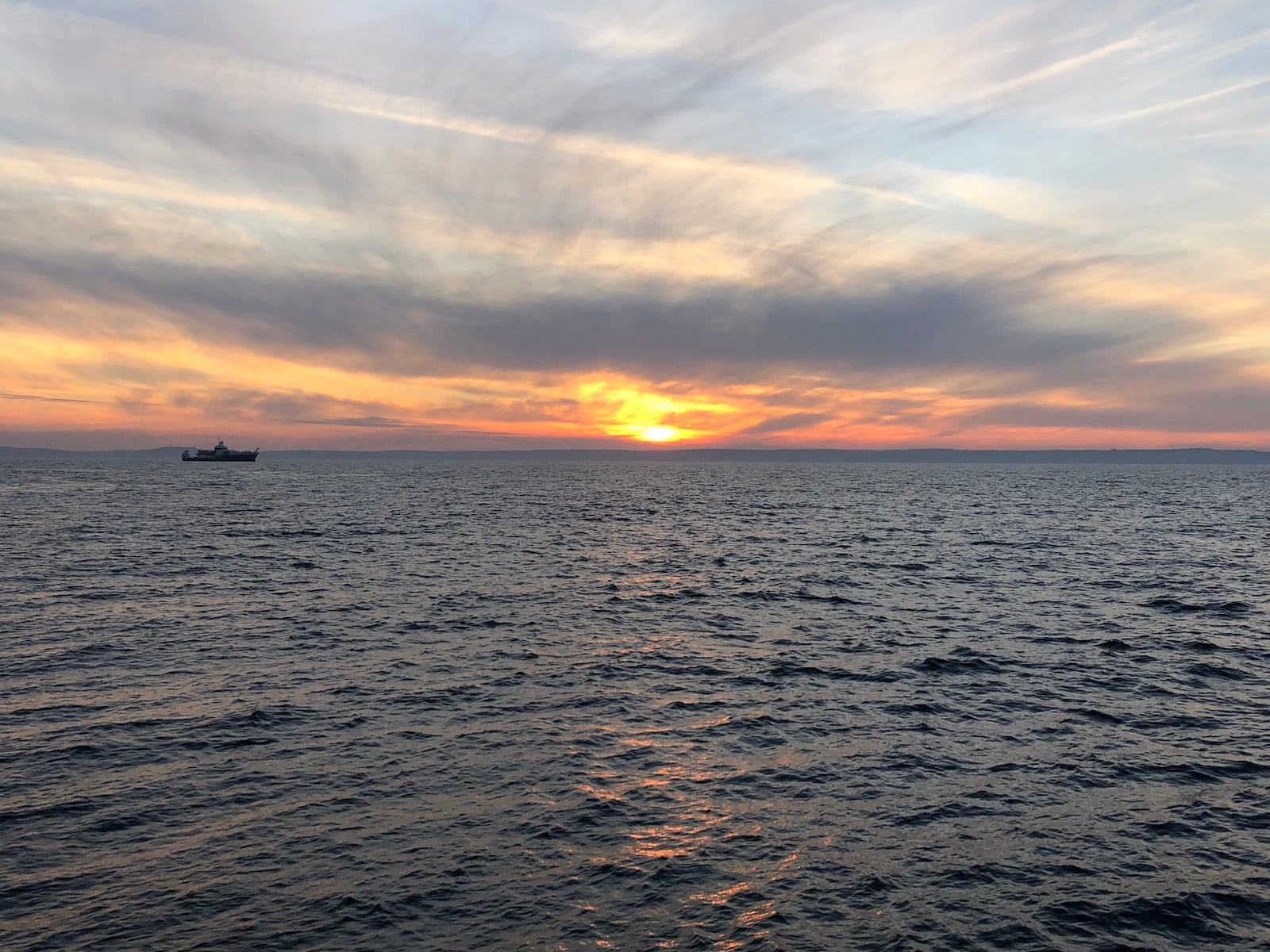 SUnset at sea, with another research vessel far in the distance.