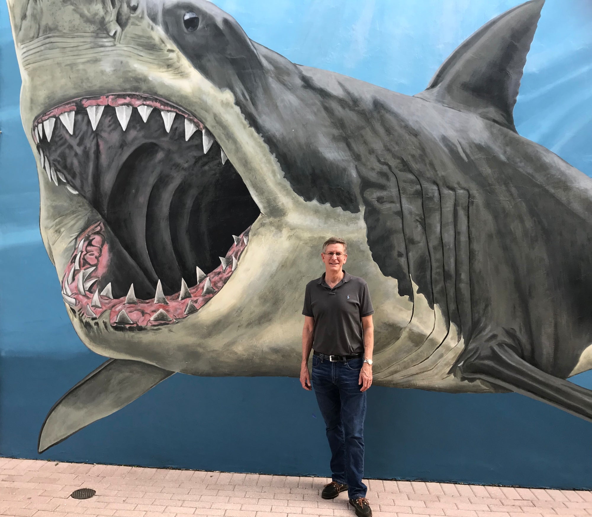 Dr. George Lauder standing in front of a painted mural of a large shark.