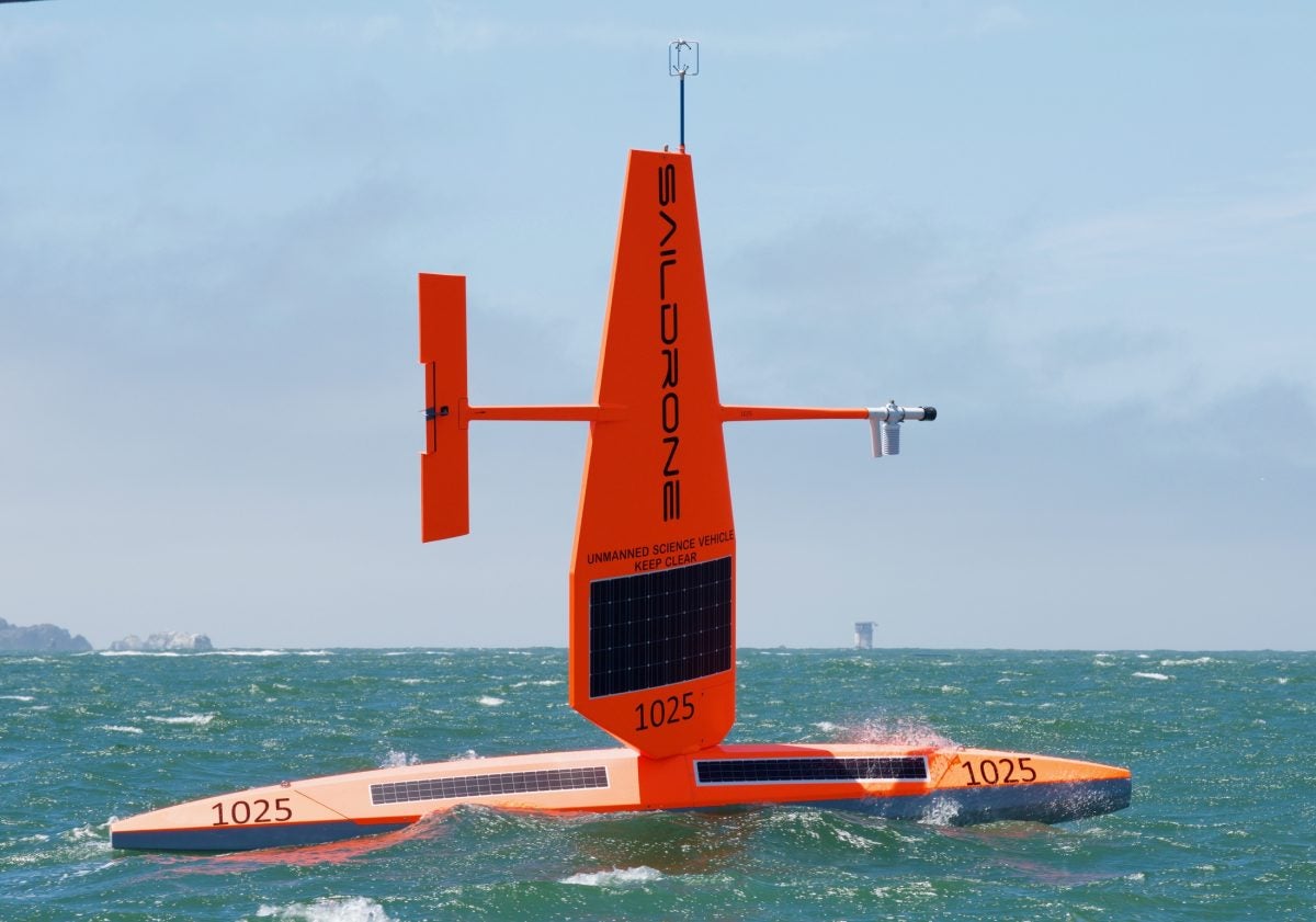 Wind-powered, brightly colored ocean drone heading out to sea.