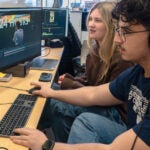 URI students Leo Bovenschulte and Ariana Temelini working together at the Social Media Agency in the Harrington School of Communication and Media