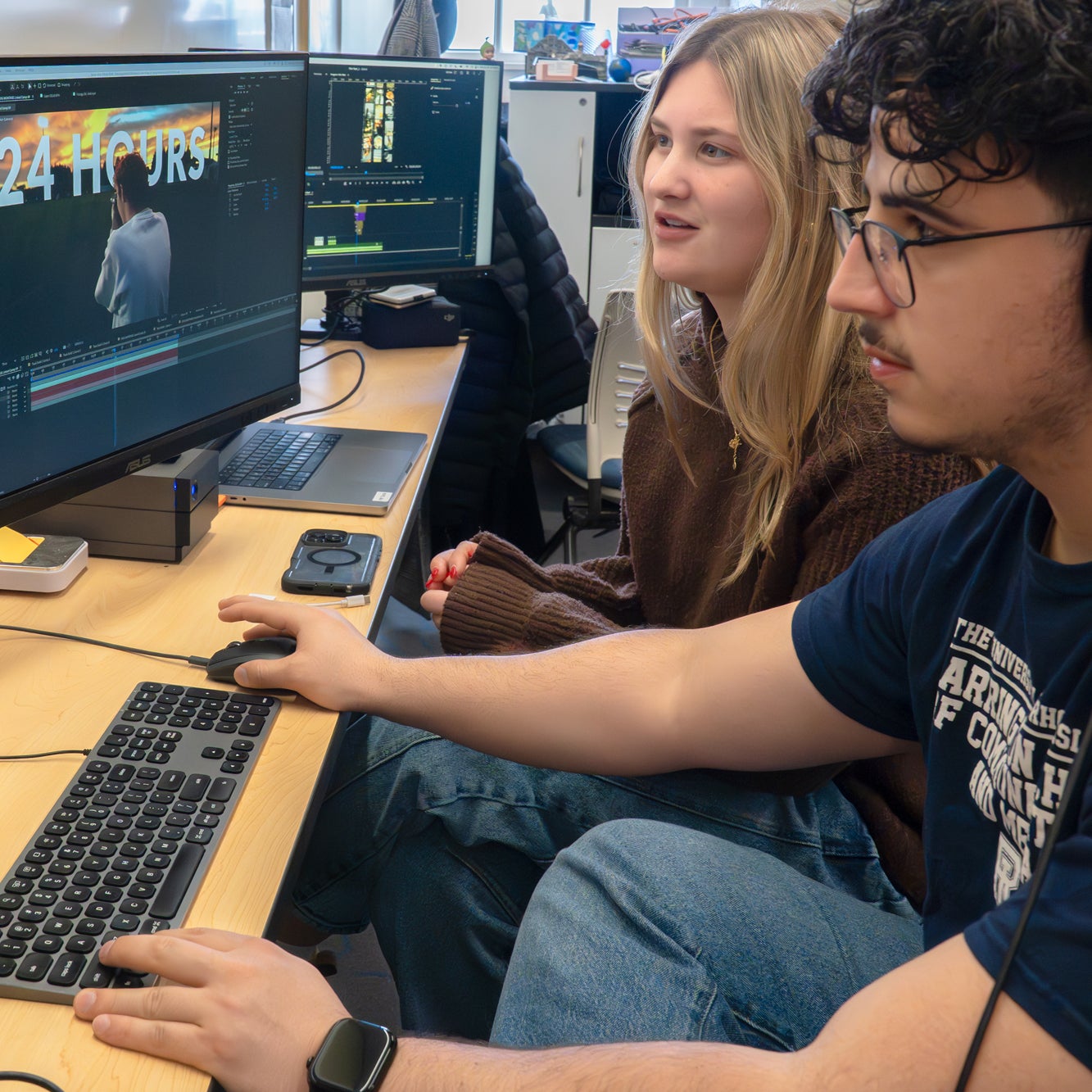 URI students Leo Bovenschulte and Ariana Temelini working together at the Social Media Agency in the Harrington School of Communication and Media