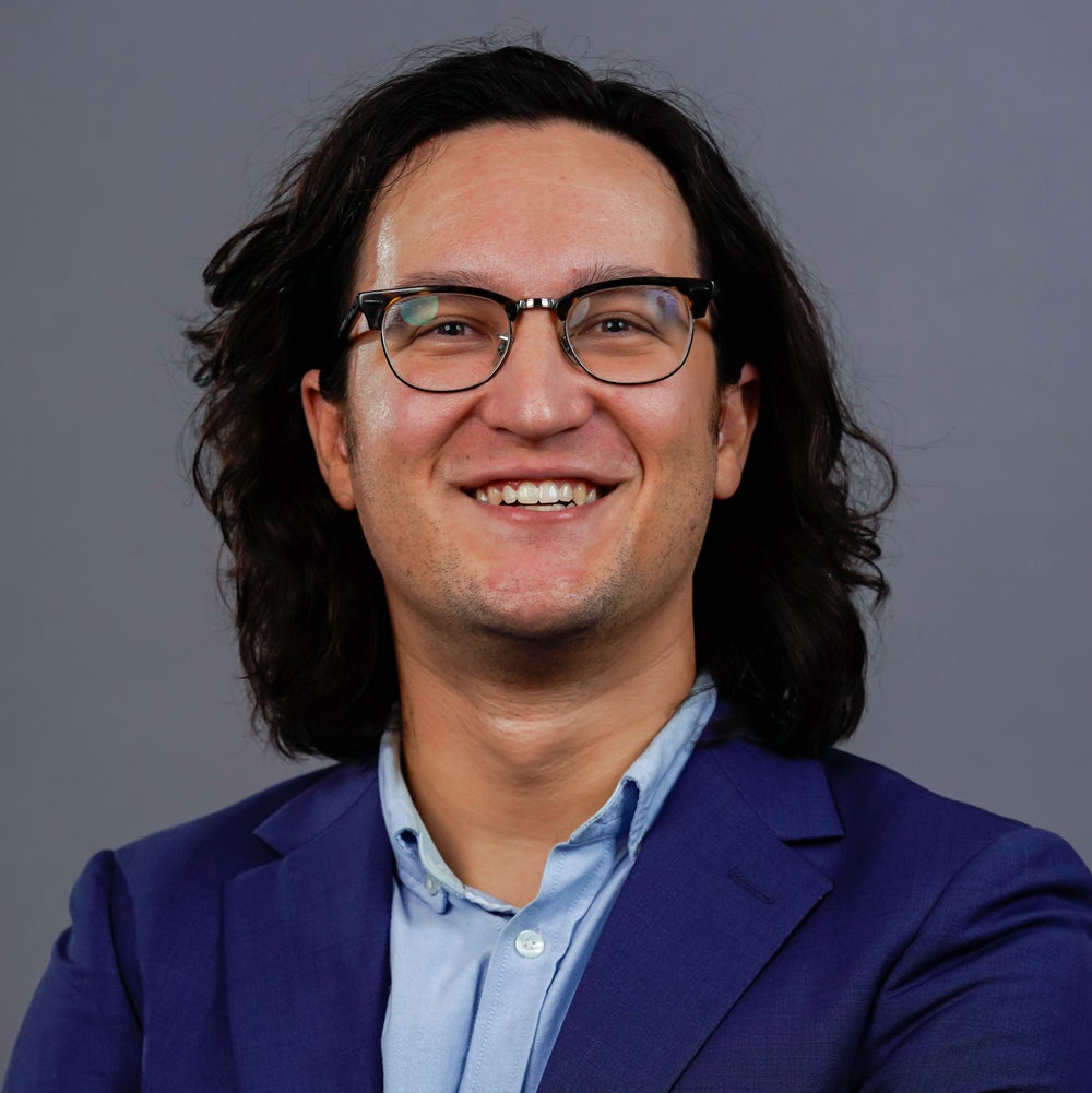 Portrait of Professor Andy Wilson in front of a solid background