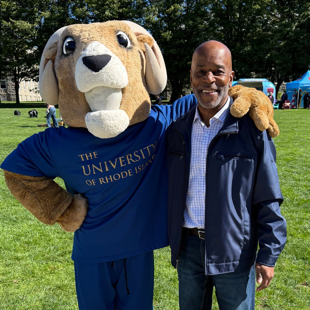 Photo of Greg Peppers on the quad posing with Rhody the Ram