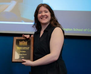 Lainey Sumner posing with her excellence award at the Harrington School Honors Ceremony