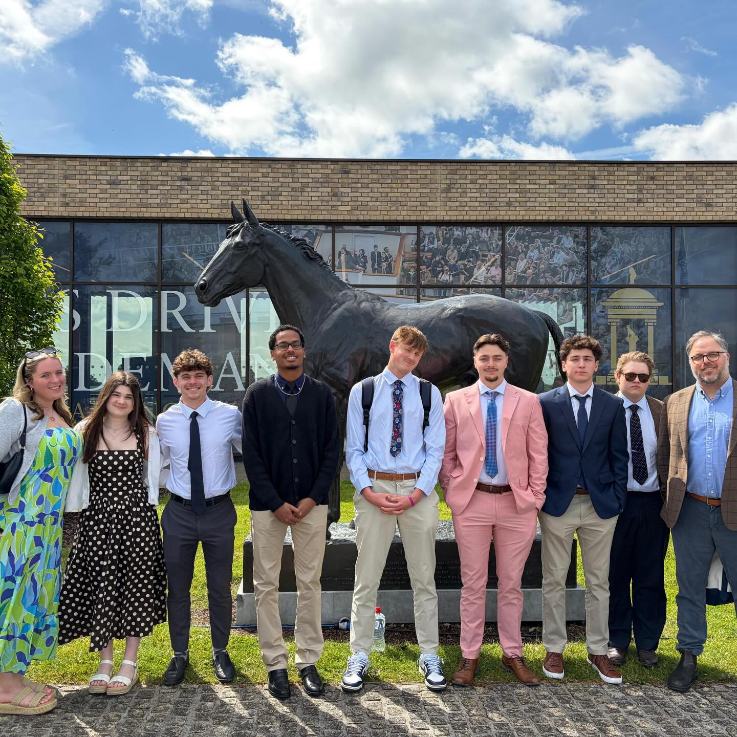 URI students and faculty studying abroad in Ireland pose in front of a horse statue during a visit to the Curragh.
