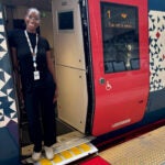 '21 alumna Naleen Camara stands in the doorway of an Amtrak train