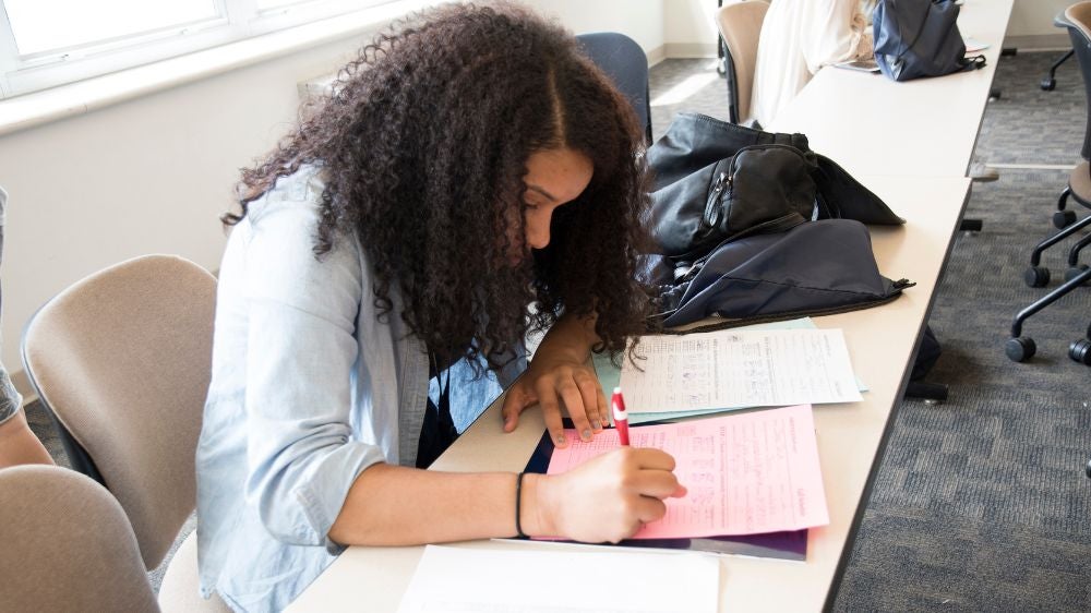 A student completes paperwork before an advising session