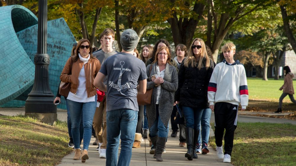 A tour guide shows prospective students and families the grounds outside of Lippitt Hall.