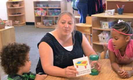A teacher uses a timer to help children plan learning activities during Plan-Do-Review. (Photos courtesy HighScope)