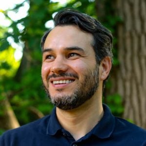 Photo of Daniel Aguirre, a smiling man with short dark hair and a beard.