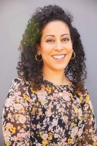 Photo of Latina women with long hair wearing flower-patterned dress. 