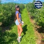 Kendall in field picking blueberries