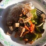 rice stir fry with veggies and tofu on a decorative plate